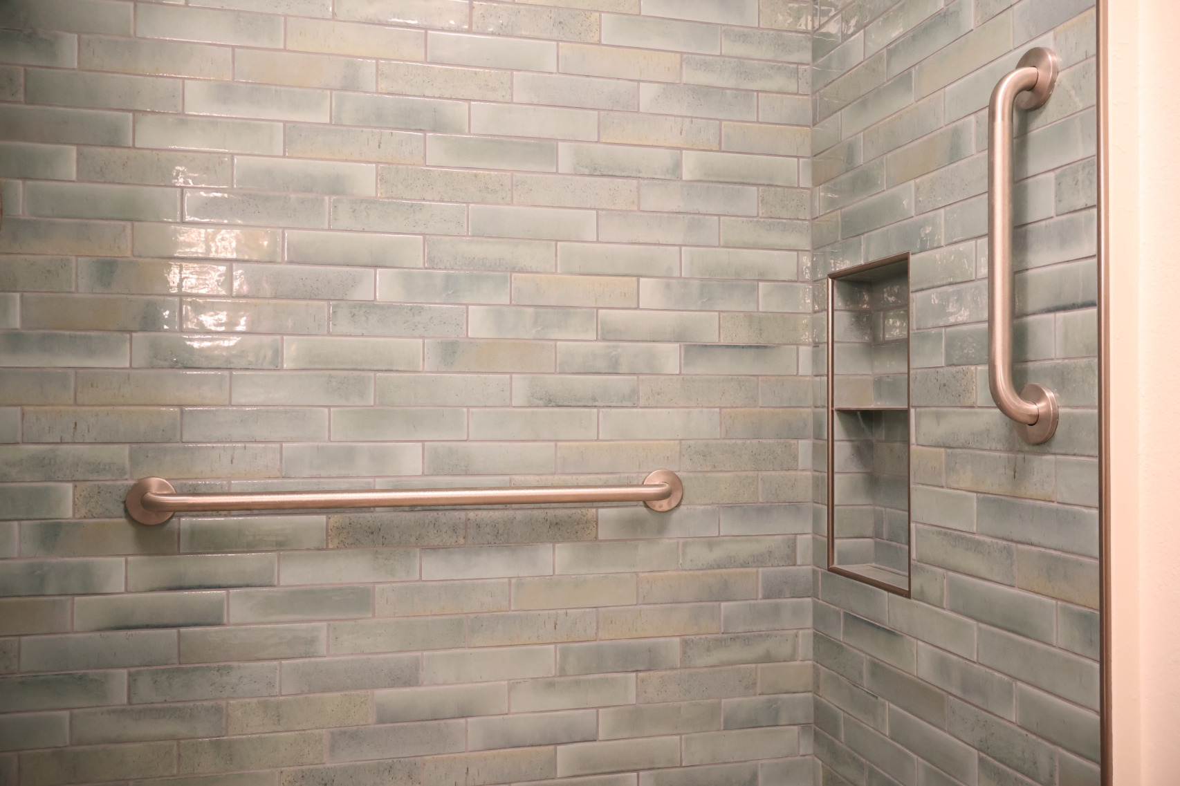 Spacious walk-in shower with Daltile Vitality tile and calming neutral finishes designed for aging in place.