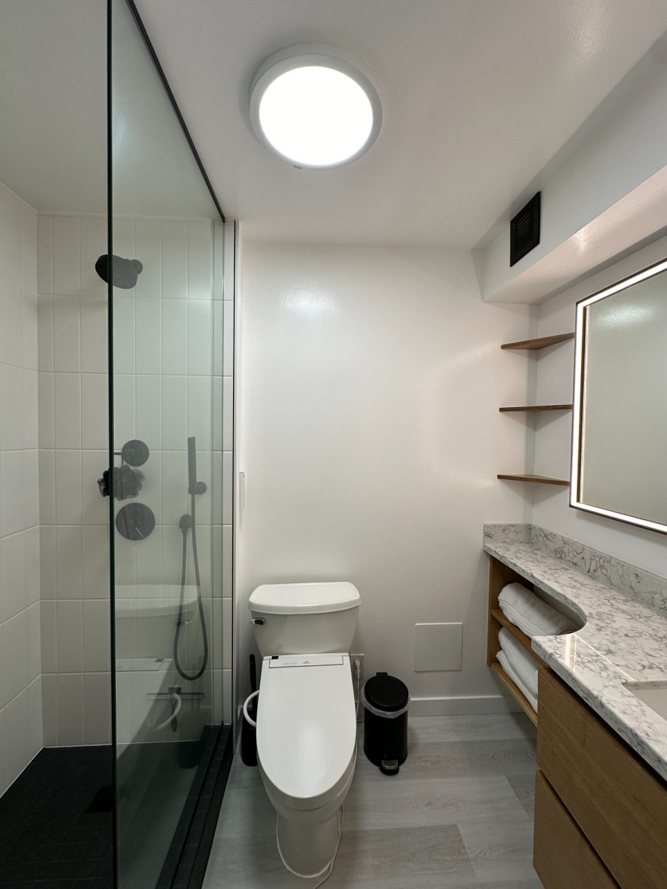 Bathroom remodel showcasing tiled shower, toilet and vanity